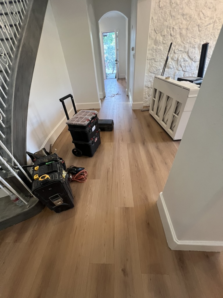 Hallway and entryway with new flooring, tools still on site, Rowlett TX
