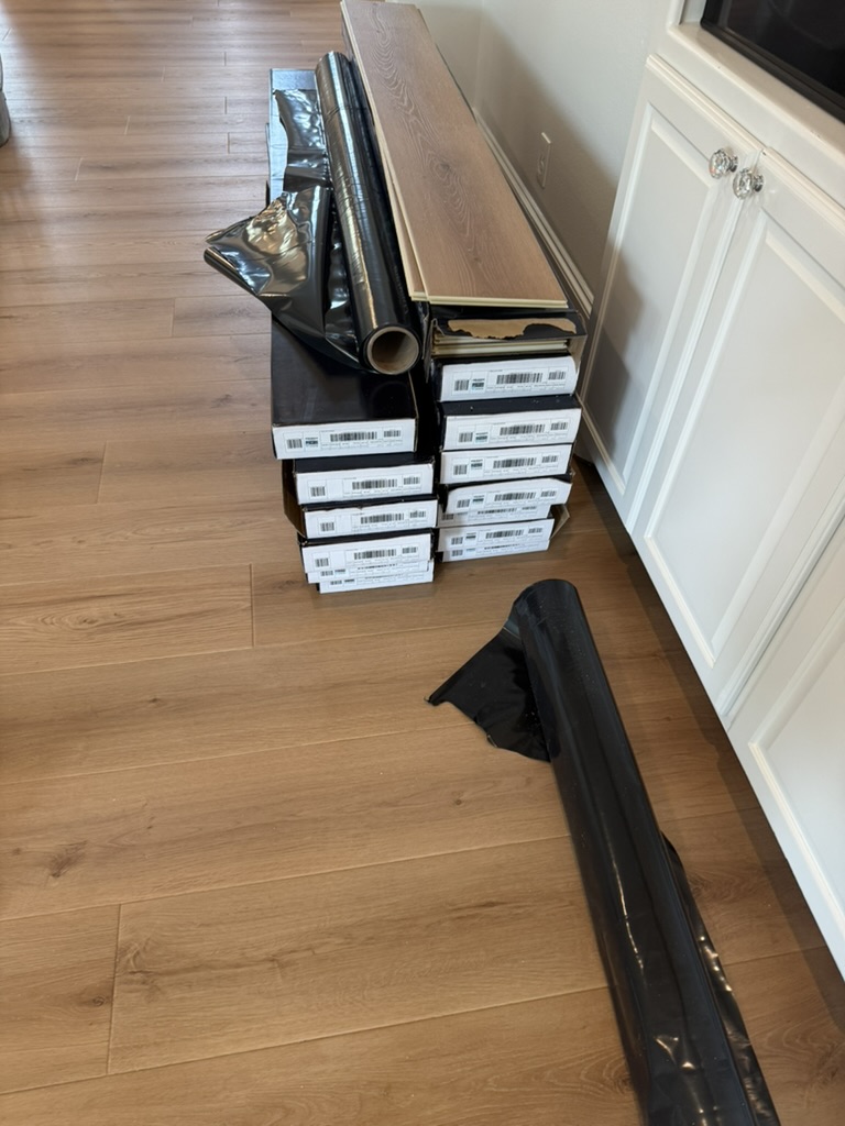 LVP flooring boxes staged for installation in Rowlett TX home after pipe burst