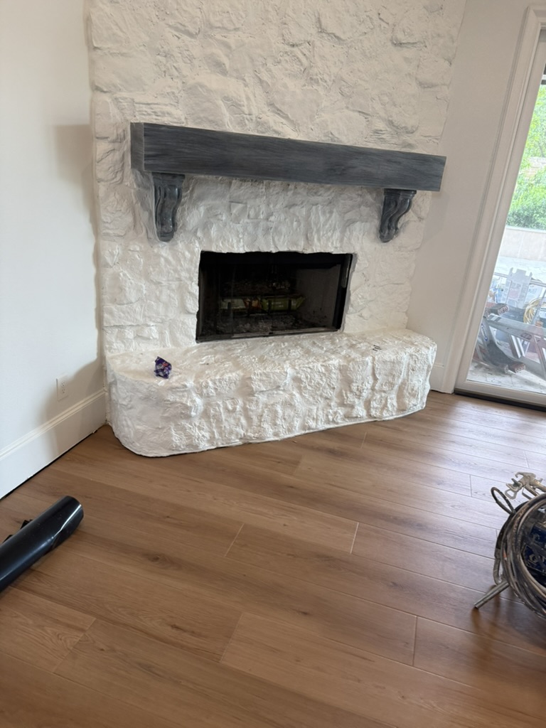 Stone fireplace with new LVP flooring installed throughout living room, Rowlett TX